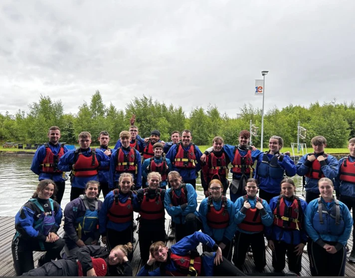 Group of Glasgow Kelvin College students wearing wetsuits and life jackets posing together at Pinkston Watersports Centre after an outdoor activity session.  Group of Glasgow Kelvin College students wearing wetsuits and life jackets posing together at Pinkston Watersports Centre after an outdoor activity session.